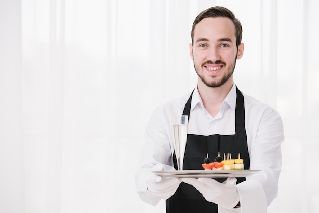 Foto grátis sommelier sorridente, mostrando a bandeja com espaço de cópia