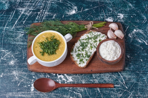 Sopa cremosa com ervas, creme de leite e pão preto.