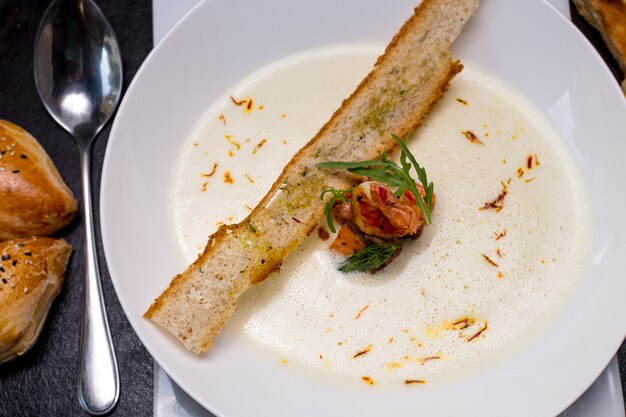 Sopa cremosa de frutos do mar camarão bolachas pãezinhos açafrão vista superior