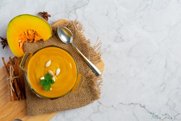 Sopa de abóbora em tigela de vidro colocada sobre tecido de saco