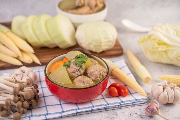 Sopa de bola de porco em um copo com um pano azul e branco.