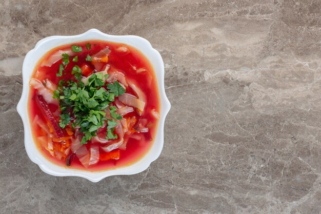 Sopa de borsch bem quente com enfeite de coentro no mármore.