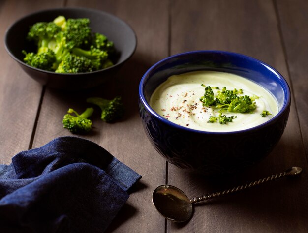 Sopa de brócolis, comida de inverno e elegante pano azul