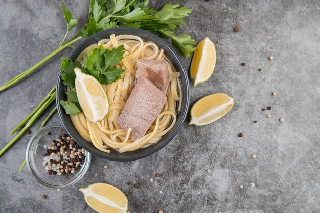 Sopa de carne e macarrão com fatias de limão