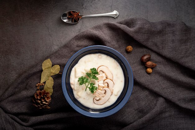 Sopa de cogumelos em uma jarra em um lenço cinza e uma colher