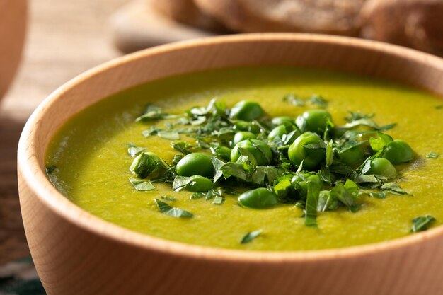 Sopa de ervilha verde em uma tigela de madeira