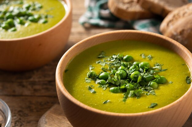 Sopa de ervilha verde em uma tigela de madeira