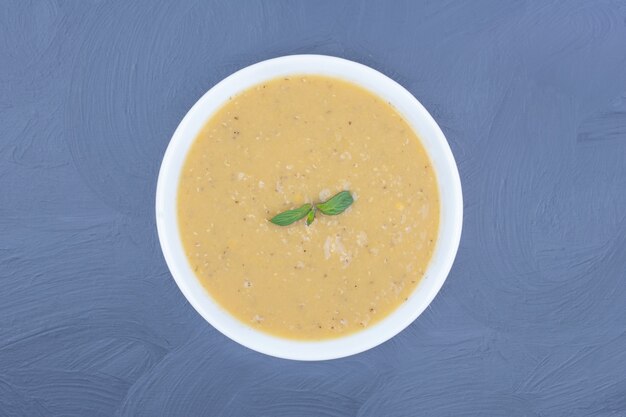 Sopa de feijão de lentilha verde em um prato branco.