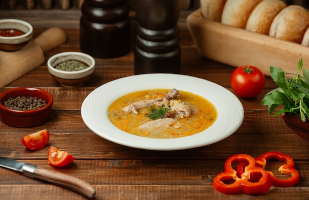 Foto grátis sopa de galinha em molho de tomate e caldo com pimentão vermelho