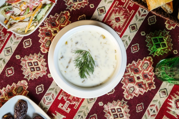 Sopa de iogurte de vista superior com ervas em um prato