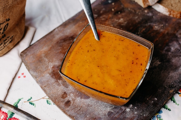 Sopa de laranja vitamina vegetal riched delicioso salgado salpicado na mesa rústica de madeira marrom