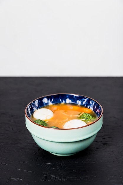 Sopa de legumes deliciosa saudável com bola de peixe na mesa preta