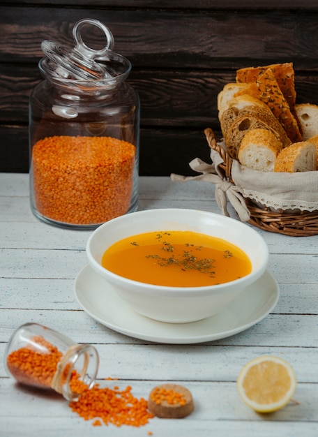 sopa de lentilha servida com fatias de limão e pão