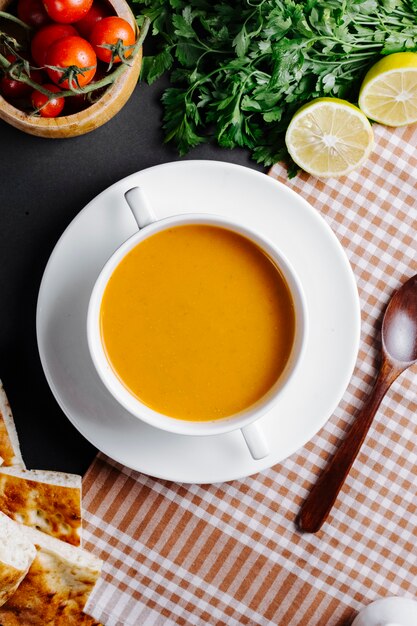 Sopa de lentilha servida com limão e verduras