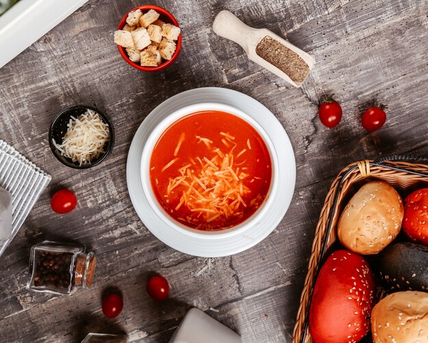 Sopa de tomate com queijo dentro e bolachas laterais