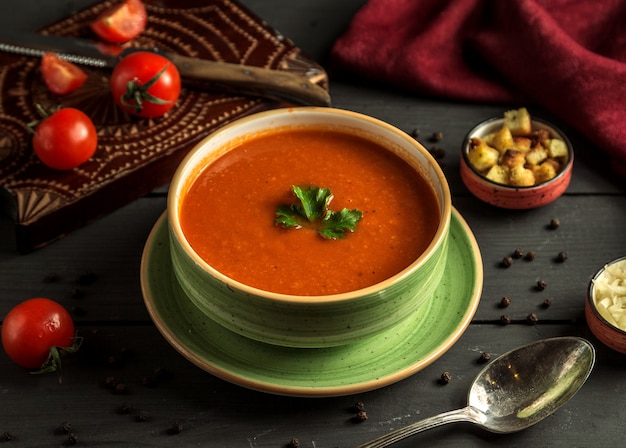 Sopa de tomate com verde em cima da mesa