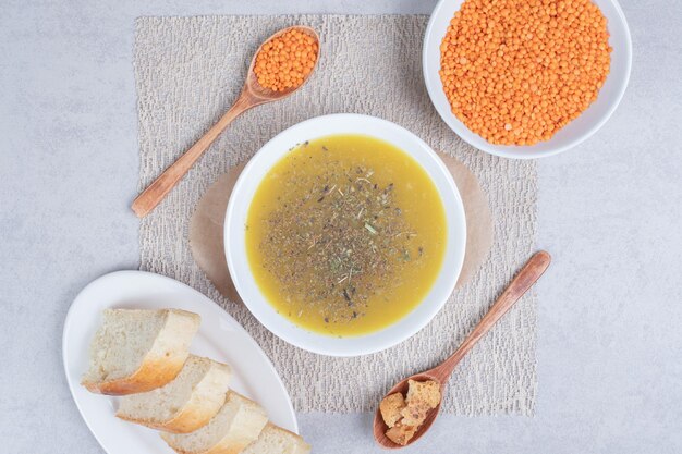 Sopa deliciosa com lentilha e colher na toalha de mesa