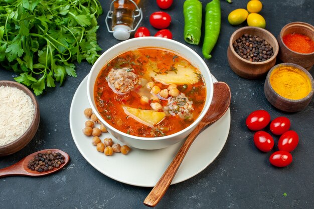 Sopa deliciosa de carne com verduras e temperos na mesa escura de frente