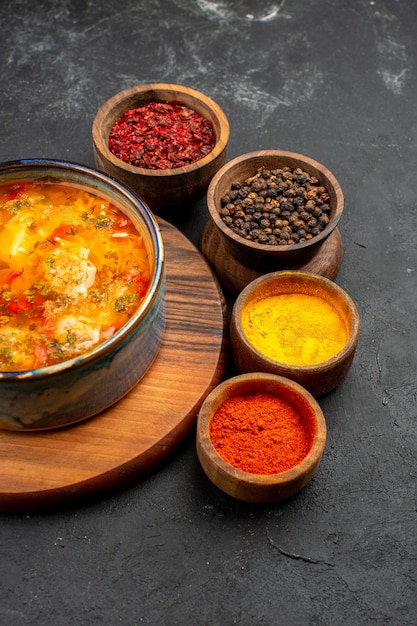 Sopa saborosa de vista frontal com temperos em espaço cinza escuro