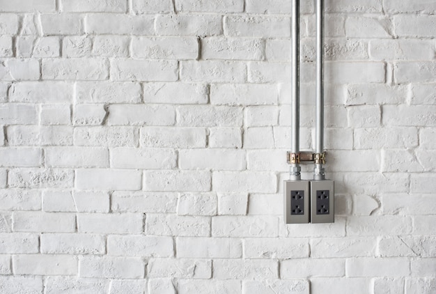 Soquete elétrico em uma parede de tijolos pintados de branco