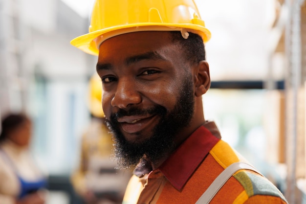 Foto grátis sorridente afro-americano jovem porteiro de armazém retrato facial