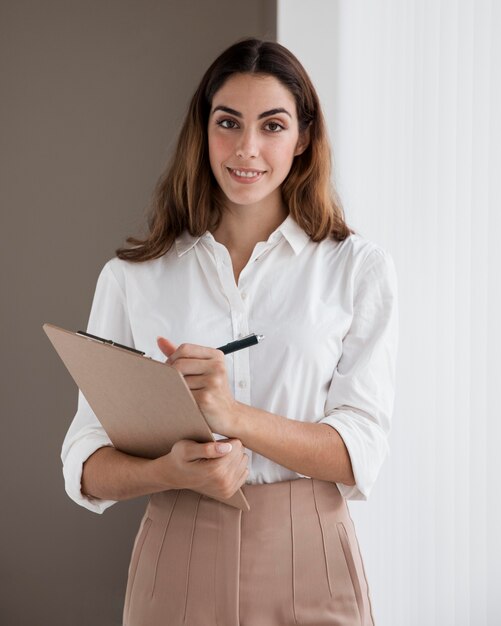 Sorridente elegante empresária segurando uma prancheta