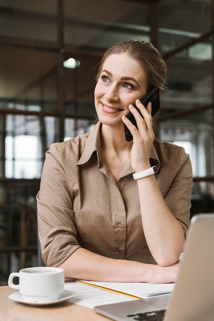 Sorridente empresária falando ao telefone durante uma reunião