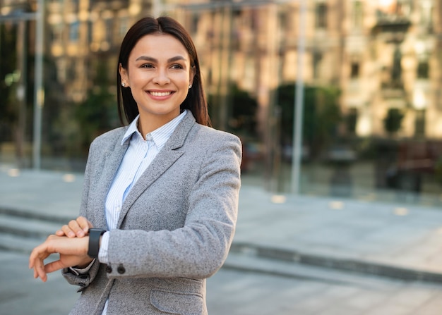 Sorridente empresária olhando para o relógio