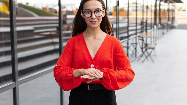 Sorridente empresária usando linguagem de sinais ao ar livre no trabalho