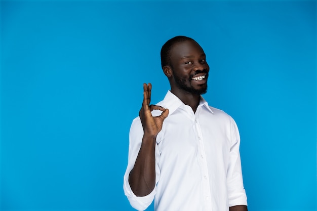 Foto grátis sorridente homem bonito mostra bem com os dedos