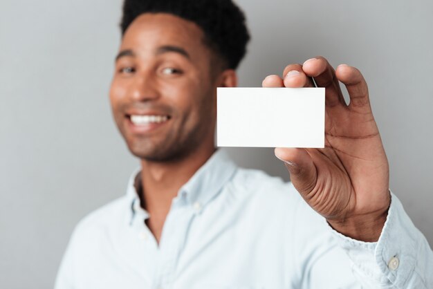 Sorridente jovem afro-americana, mostrando o cartão de visita em branco