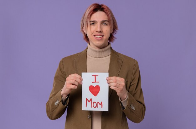 Sorridente jovem bonito segurando uma carta para sua mãe. Feliz Dia das Mães