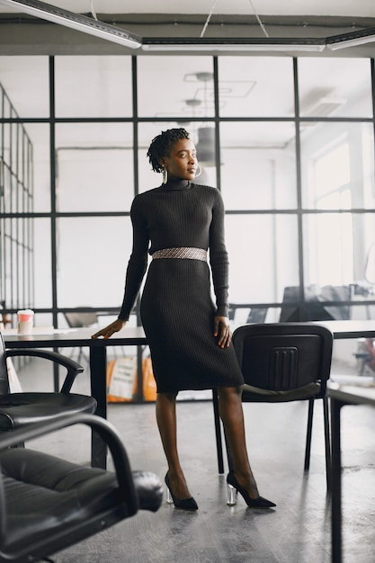 Sorridente jovem empresária afro-americana, trabalhando em um escritório. Conceito de negócios.