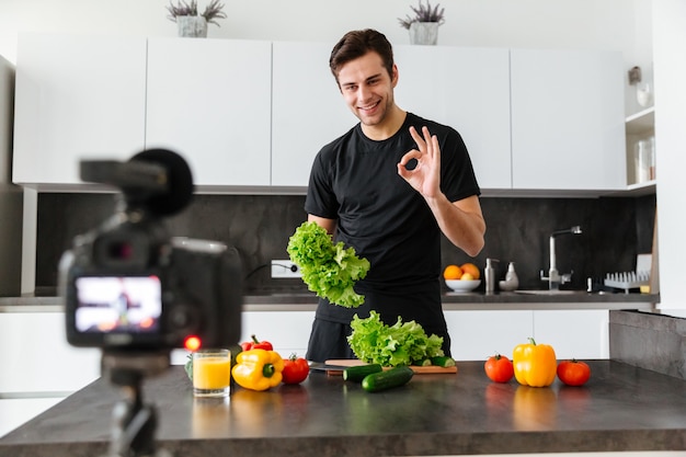 Sorridente jovem filmando seu episódio de blog de vídeo