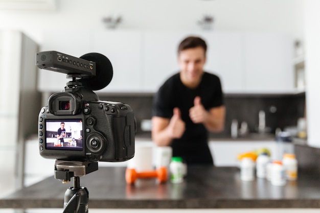 Sorridente jovem filmando seu episódio de blog de vídeo