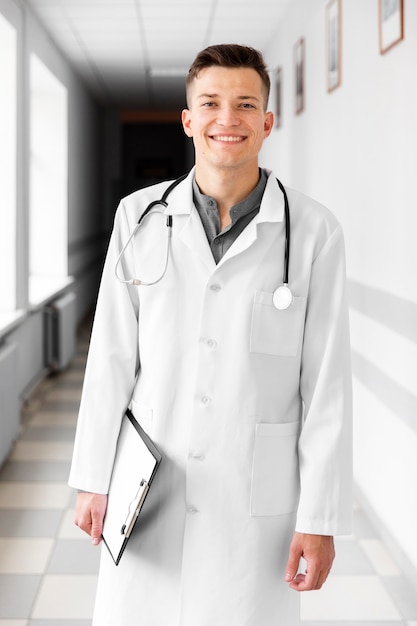 Sorridente jovem médico no corredor do hospital