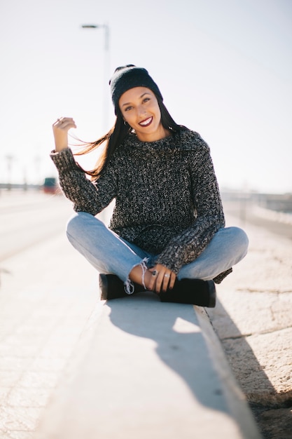 Sorridente mulher sentada em ambiente urbano