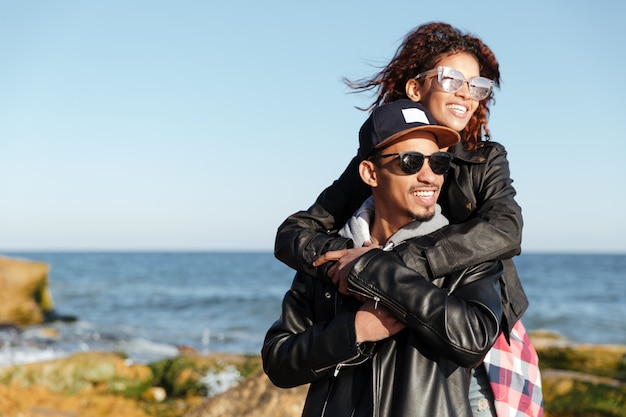 Sorrindo africano casal apaixonado caminhando ao ar livre na praia