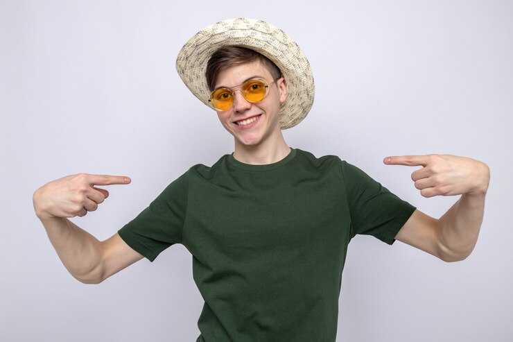 Foto grátis sorrindo, apontando para si mesmo, jovem bonito usando óculos e chapéu