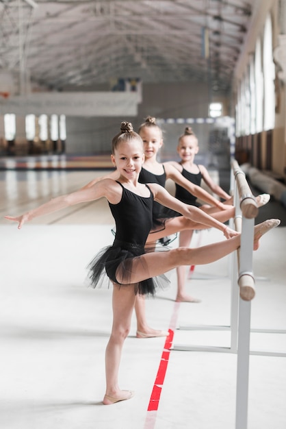 Foto grátis sorrindo, bailarina, meninas, esticar, dela, perna, ligado, barzinhos