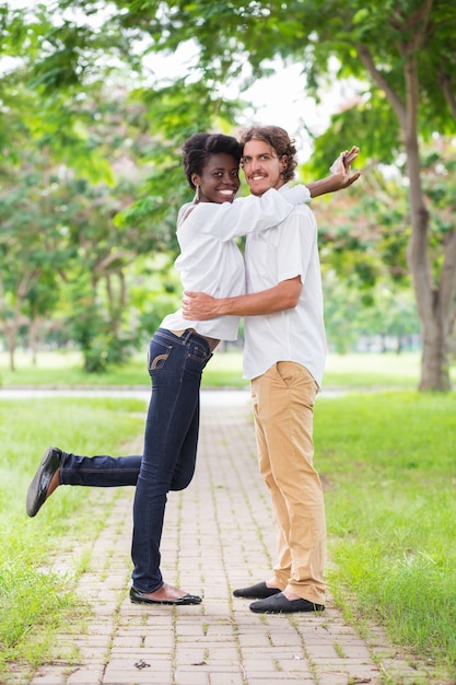 Sorrindo casal abraçando e olhando câmera