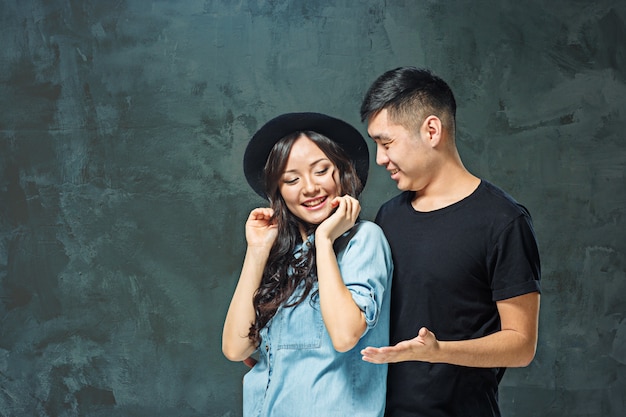 sorrindo casal coreano em cinza