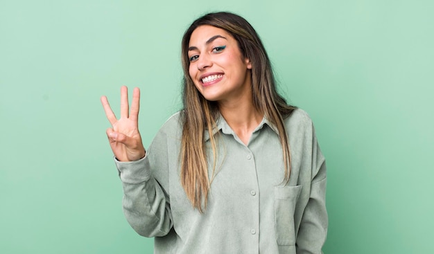 sorrindo e parecendo amigável mostrando o número três ou terceiro com a mão em contagem regressiva