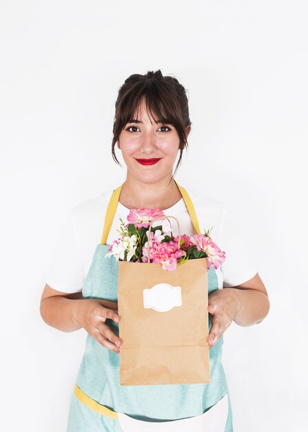 Sorrindo florista feminina segurando o saco de papel cheio de flores frescas