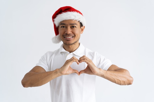 Sorrindo homem asiático fazendo gesto de coração com as mãos