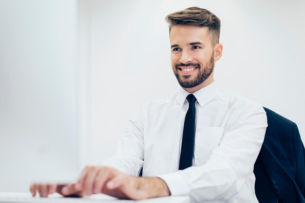 sorrindo homem de digitação elegante em um computador