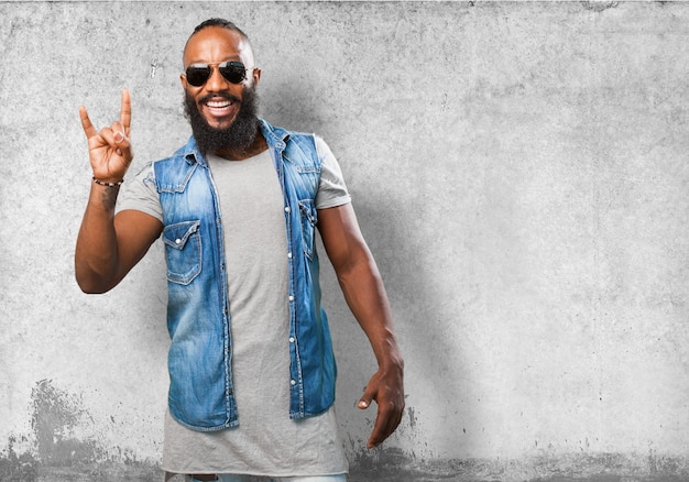 Foto grátis sorrindo homem que faz chifres com a mão