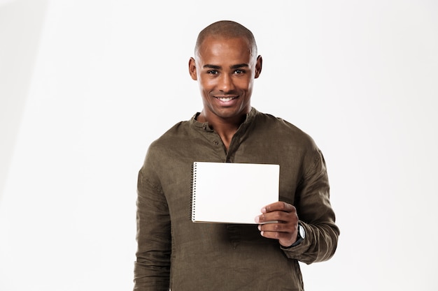 Sorrindo jovem africano mostrando o caderno.