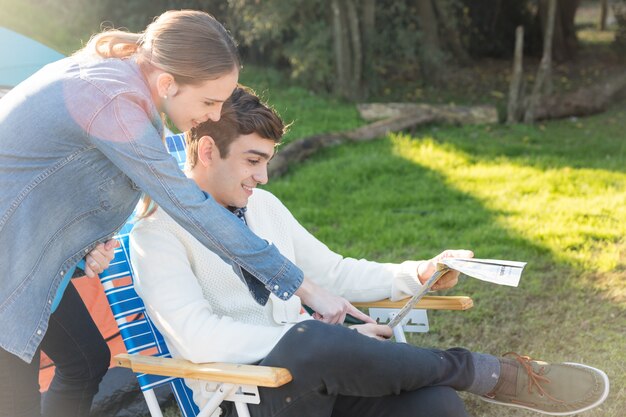 Sorrindo jovem casal com um mapa ao ar livre