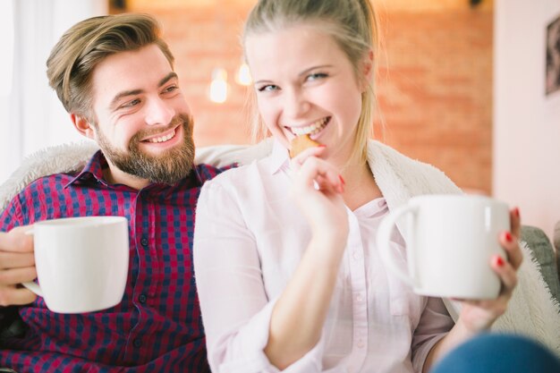 Sorrindo jovem casal com xícaras